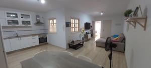 een keuken en een woonkamer met een tafel en stoelen bij LA CASITA VECINDARIO in Vecindario
