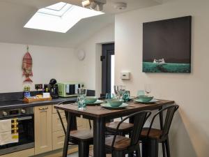 Fifie Cottage في Johnshaven: مطبخ مع طاولة خشبية بأربعة كراسي