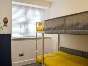 a bunk bed in a room with a yellow bed at Fifie Cottage in Johnshaven