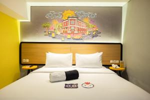 a hotel room with a bed with a painting on the wall at Nite & Day Semarang - Candi in Semarang