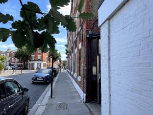 a car parked on a street next to a building at Bright & modern 1-bed flat in the heart of Fulham in London