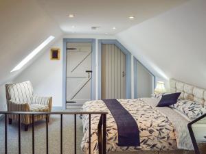 a bedroom with a bed and a chair at The Coach House in Cove
