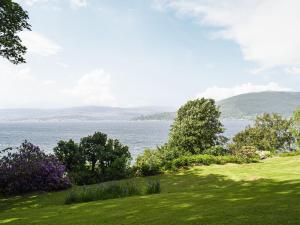 a grassy field with a view of the water at The Coach House in Cove