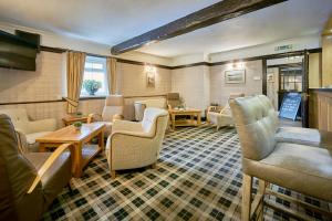 a waiting room with couches and chairs and a table at The Old Ginn House Inn in Great Clifton