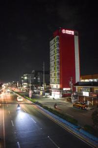 um edifício iluminado numa rua da cidade à noite em Sempre Premier Inn - MACTAN AIRPORT HOTEL em Mactan