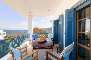 einen Balkon mit einem Tisch, Stühlen und Meerblick in der Unterkunft Iris - Διαμέρισμα σε πολυκατοικία ως ολόκληρος χώρος in Souvala