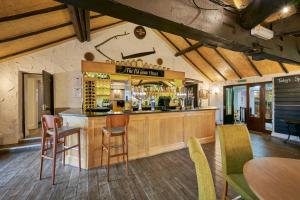 a bar in a restaurant with chairs and tables at The Old Ginn House Inn in Great Clifton