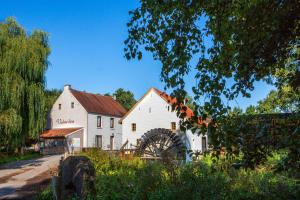 un grand bâtiment blanc avec un bain d'amille devant lui dans l'établissement Vakantieverblijf Volmolen B&B, à Maaseik