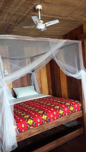 uma cama num quarto com tecto em CASE de ROBINSON em Lomé