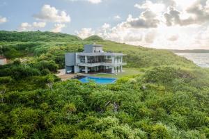 an aerial view of a house on a hill next to the water at Castello do mare カステロディマーレ in Miyako Island