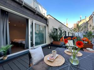 un patio con mesa y flores en el balcón en Old Town 2 Room Apartments, en Düsseldorf