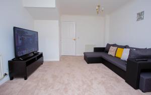 a living room with a couch and a flat screen tv at Intellect Suites in Northampton