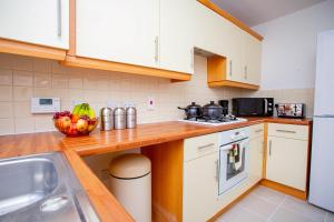 a kitchen with white cabinets and a bowl of fruit on the counter at Intellect Suites in Northampton