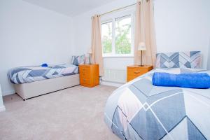 a bedroom with two beds and a window at Intellect Suites in Northampton