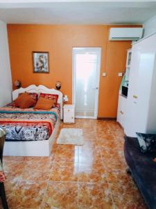 una camera con letto e parete arancione di Chez Marina a Quatre Bornes