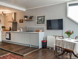 uma cozinha com uma mesa e uma televisão na parede em Wellesley Retreat em Hastings