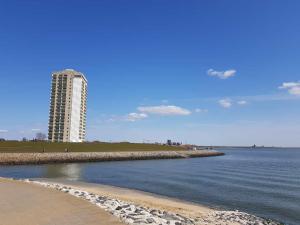 a beach with a tall building in the background at Kleine Hafenperle Büsum in Büsum