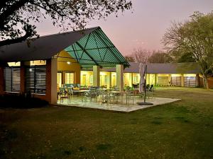 Champagne Valley的住宿－Drakensberg Inkosana Lodge，院子内带桌椅的建筑