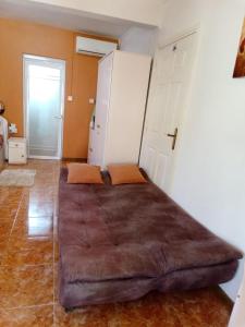 un grande letto marrone in una stanza con porta di Chez Marina a Quatre Bornes