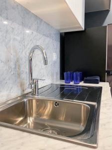 a stainless steel sink in a kitchen with two blue glasses at Dar Vacation - Blue Spacious Luxury Apartment in Dubai