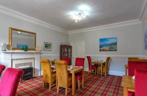 a dining room with a table and chairs and a fireplace at Southbank Guesthouse in Elgin