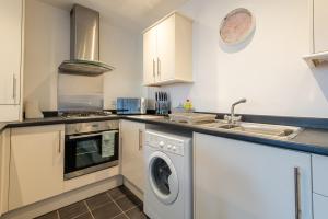 a kitchen with a washing machine and a sink at No 14 in Mansfield