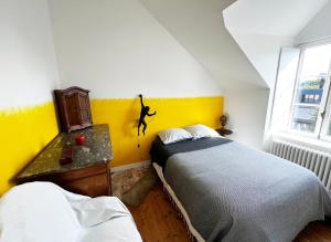 a bedroom with two beds and a yellow wall at Villa Sainte Claire in Saint Malo