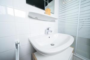 a white bathroom with a sink and a shower at Studio WHITE - Central - Balcony - Fair - Kitchen in Neuss +12 photos