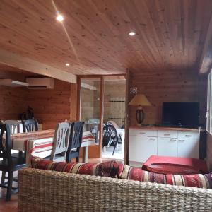 sala de estar con sofá, mesa y TV en la cabane au fond du jardin, en Arsac