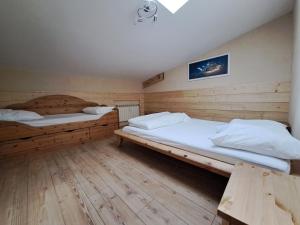 Duas camas num quarto com pisos em madeira em Aillon Evasion 12 em La Correrie