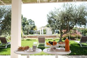 a table with bread and fruit on it in a yard at ALMASOL - Charme Experience in Castellana Grotte