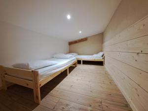 two beds in a room with wooden walls at Aillon Evasion 12 in La Correrie