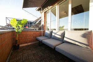 a couch sitting on a balcony with a window at Studio WHITE - Central - Balcony - Fair - Kitchen in Neuss