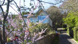 Marshlands Apartment في لويس: منزل به زهور وردية أمام السياج