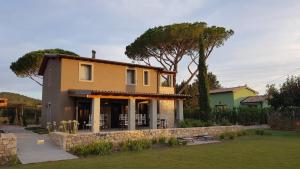 una casa gialla con un muro di pietra di Agriturismo Resort Il Foionco a Massa Marittima
