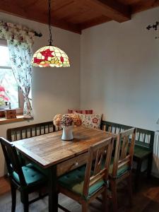 a dining room table with chairs and a vase with flowers at Chalupa U kapličky 