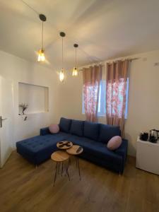sala de estar con sofá azul y mesa en Apartmani Home, en Zajecar