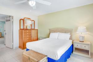a bedroom with a bed and a dresser with a lamp at A Little Piece of Paradise in Marathon