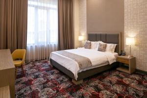 a hotel room with a bed and a window at Sphera by Stellar Hotels, Yerevan in Yerevan