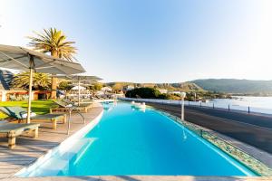 a swimming pool with chairs and a view of the water at Harbour House Hotel in Hermanus