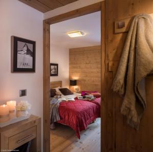 a bedroom with a bed with a red blanket at CGH Résidence Boutique Le Lodge des Neiges in Tignes