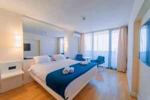 a bedroom with a large bed with two blue chairs at Superior Sea View Aparthotel in Orbi City Batumi in Batumi