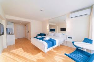 1 dormitorio con 1 cama y 2 sillas azules en Superior Sea View Aparthotel in Orbi City Batumi, en Batumi