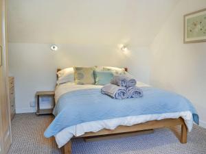 a bedroom with a bed with blue sheets and pillows at Summerlea Cottage in Moffat