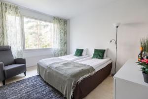 - une chambre avec un lit, une chaise et une fenêtre dans l'établissement Family Home Vanamo, à Rovaniemi