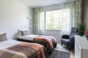 - une chambre avec deux lits, une chaise et une fenêtre dans l'établissement Family Home Vanamo, à Rovaniemi
