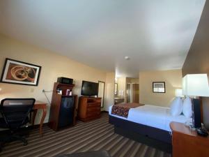 a hotel room with a large bed and a desk at Best Western Manhattan Inn in Manhattan +18 photos