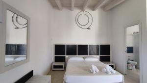 Habitación blanca con cama y espejo en Le Zagare di Vendicari en Noto Marina