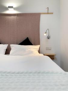 ein Schlafzimmer mit einem weißen Bett und einer Lampe in der Unterkunft Premium Design Ferienhäuser Mosel Chalets in Pommern