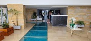 uma mulher parada na entrada de um prédio com piscina em AZ Apartments em Cartagena das Índias